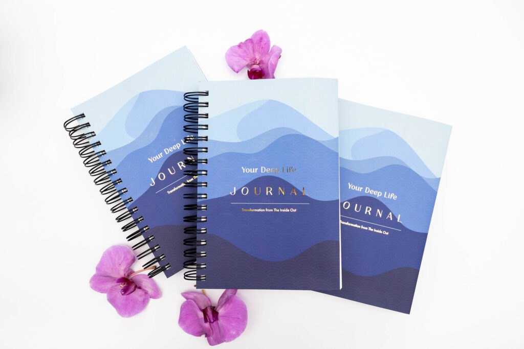Flat‑lay product photo of a spiral‑bound journals titled “Your Deep Life” with purple flowers — photographed by Marta Raptis in Mississauga.
