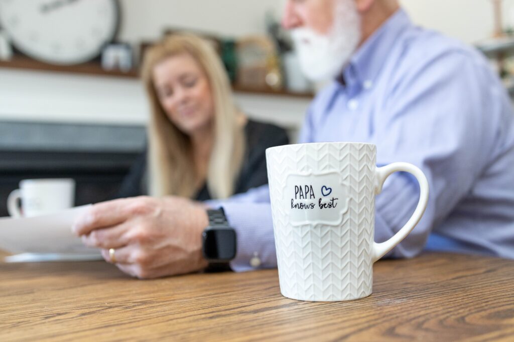 Branding photo of Frank Gasper sitting at a wooden table with a white coffee cup, captured in a relaxed business setting — photographed by Marta Raptis in Mississauga.