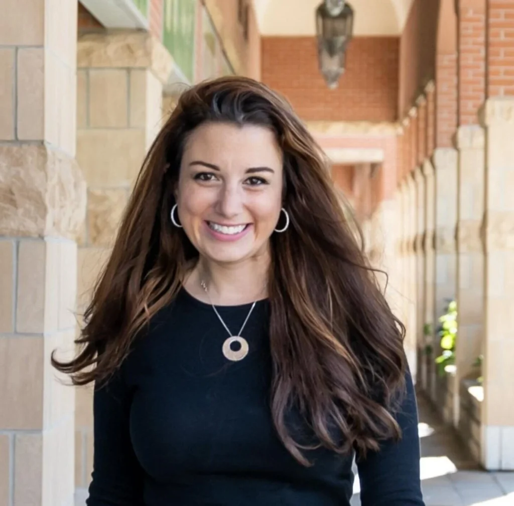 Personal branding portrait of Georgina Bloom standing outdoors near a brick building, smiling in natural light — photographed by Marta Raptis in Mississauga center