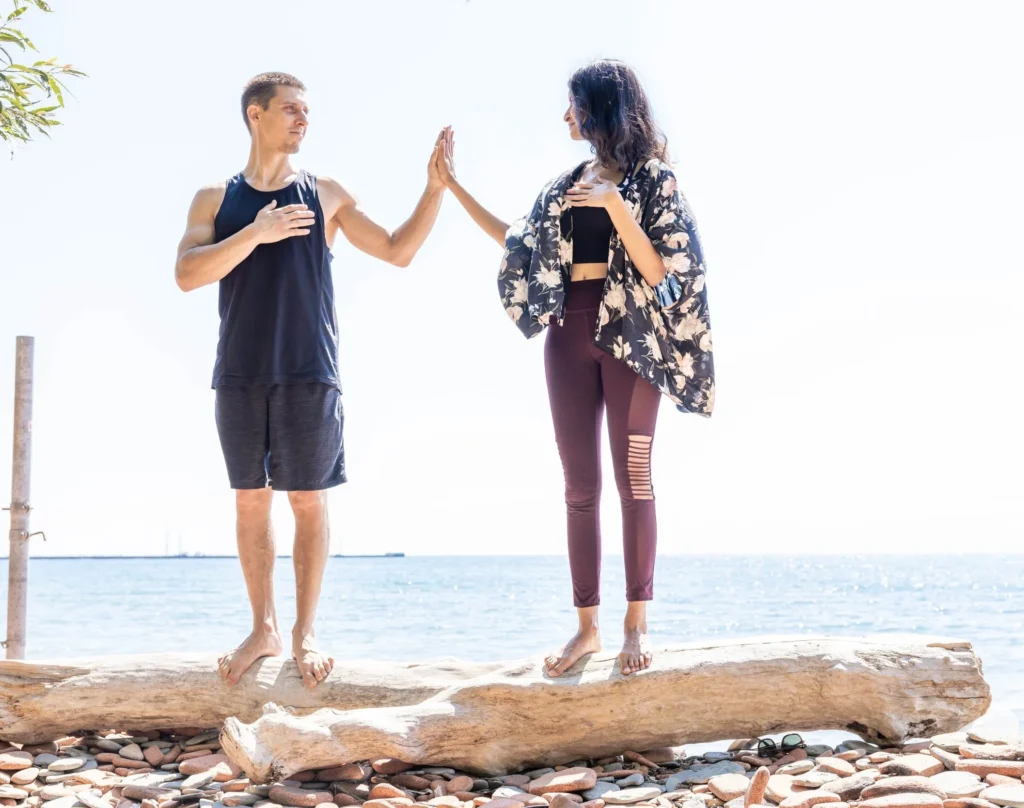 Lifestyle branding photo of Danielle D’Souza and partner high‑fiving on a rocky lakeshore — photographed by Marta Raptis in Oakville.