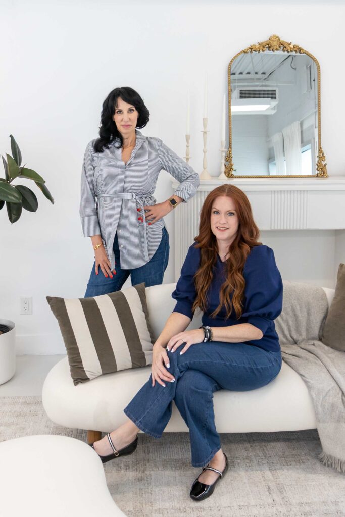 Samara Foisy and Allison Jorgens seated on sofa in bright studio, photographed for Qwiky Wellness branding shoot by Marta Raptis.