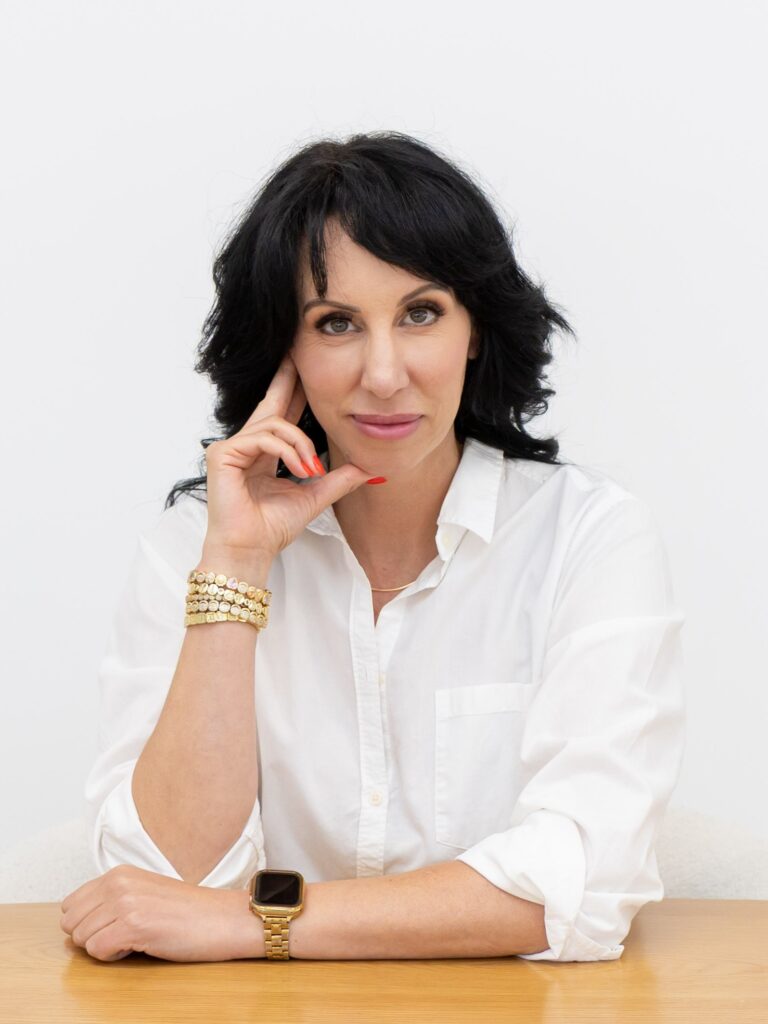Samara Foisy seated at desk with thoughtful expression, photographed for Qwiky Wellness branding shoot by Marta Raptis.
