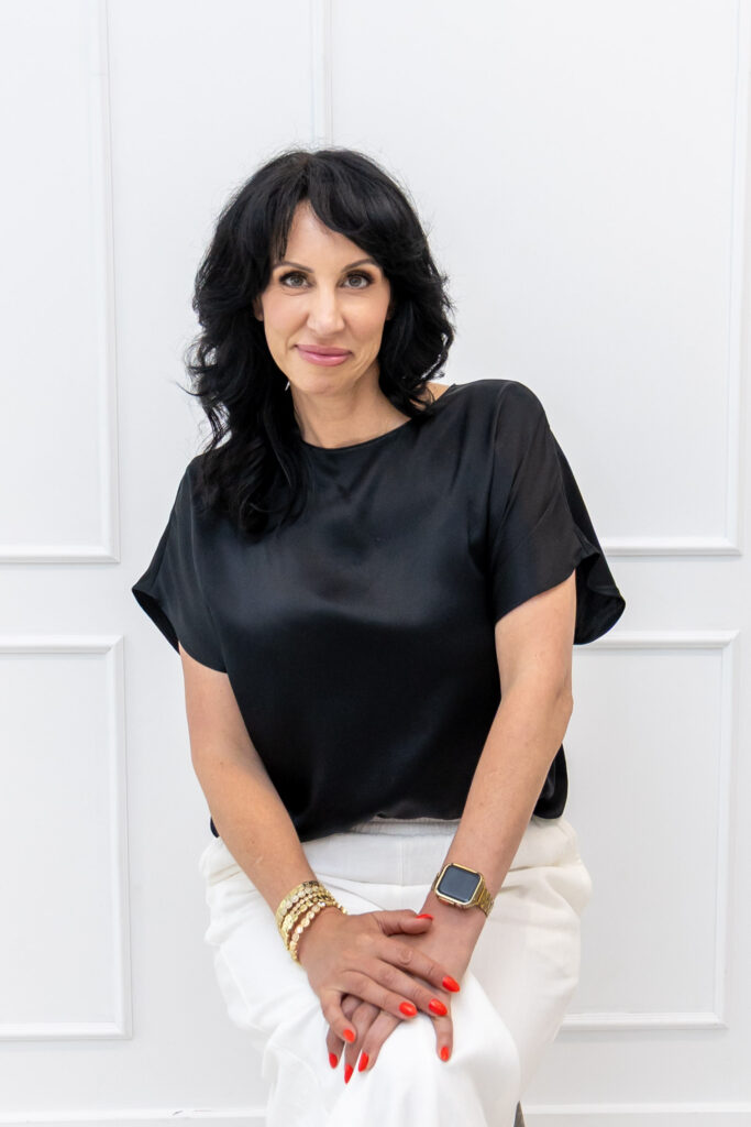 Samara Foisy standing in black top with soft smile, photographed for Qwiky Wellness branding shoot by Marta Raptis.