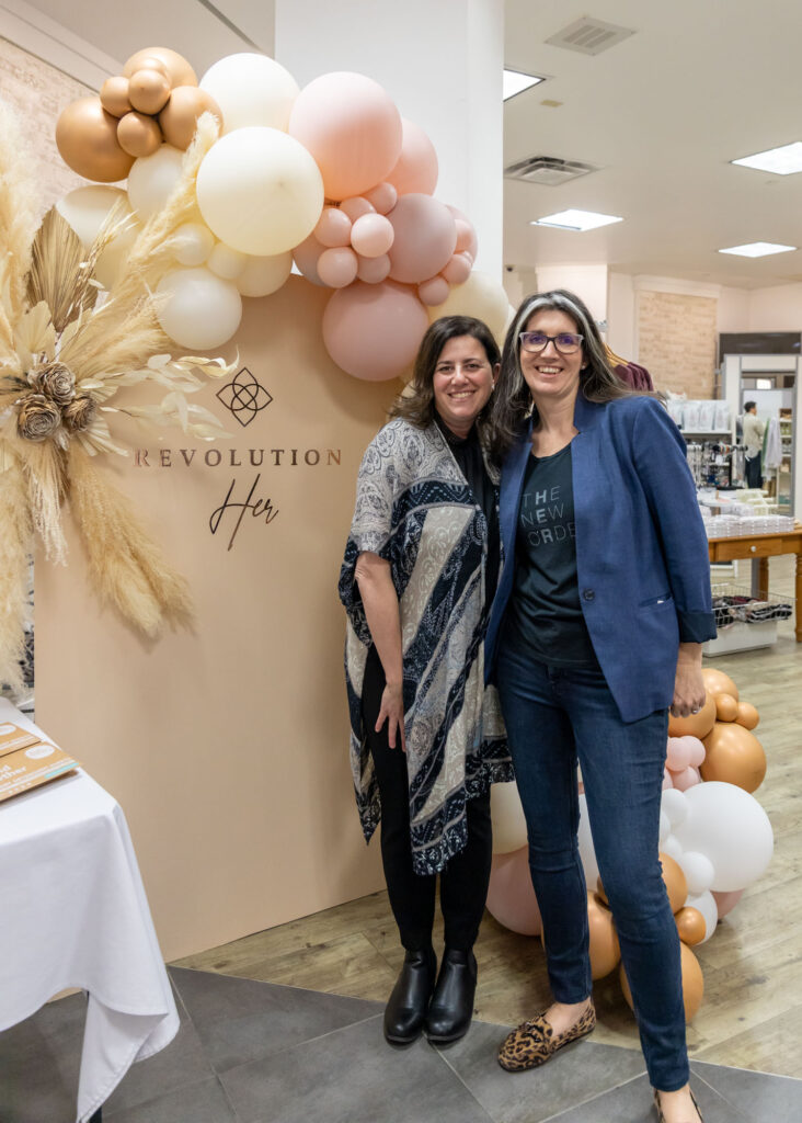 Branding photo of two women business owners standing in front of a balloon and floral backdrop during a Mississauga event