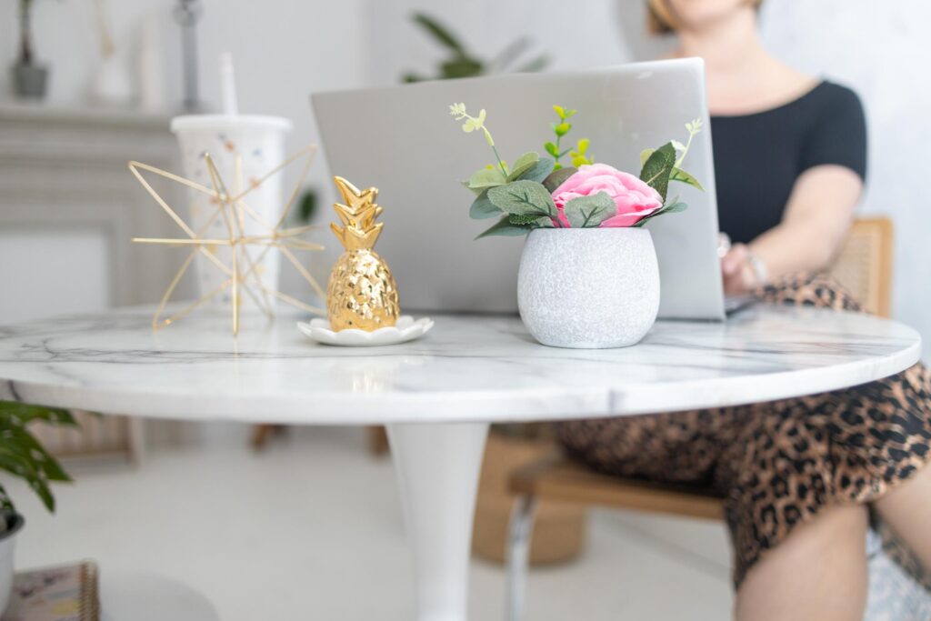 Woman working remotely from a cozy home office with laptop and coffee, representing creative online business freedom.